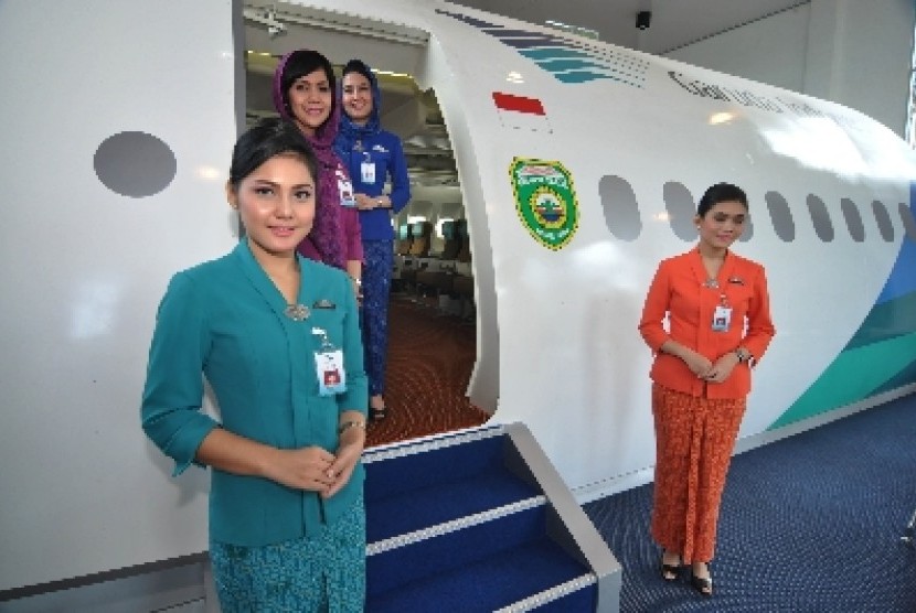 Pramugari berdiri di mock up (replika) Pesawat Garuda di kompleks Asrama Haji Palembang, Sumatera Selatan. Bukan cuma bersikap ramah, ada alasan pramugari menyambut dan menyapa penumpang di pintu pesawat.