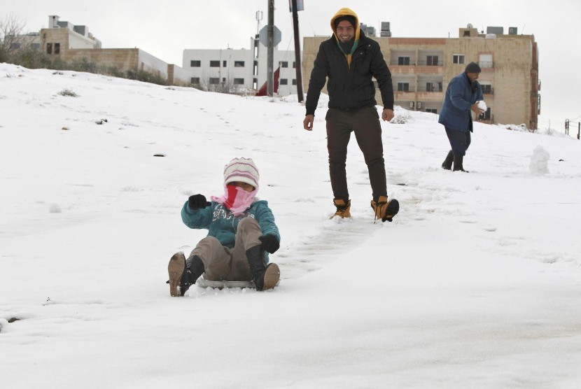  Sejumlah pria bermain salju setelah badai salju menerpa kota Amman,Yordania, Rabu (9/1).  (Reuters/Muhammad Hamed)