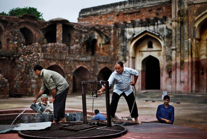 Sejumlah pria menimba air dari sumur untuk kebutuhan wudhu jamaah sebelum shalat Jumat pertama Ramadhan di masjid peninggalan era Mughal, New Delhi, India,