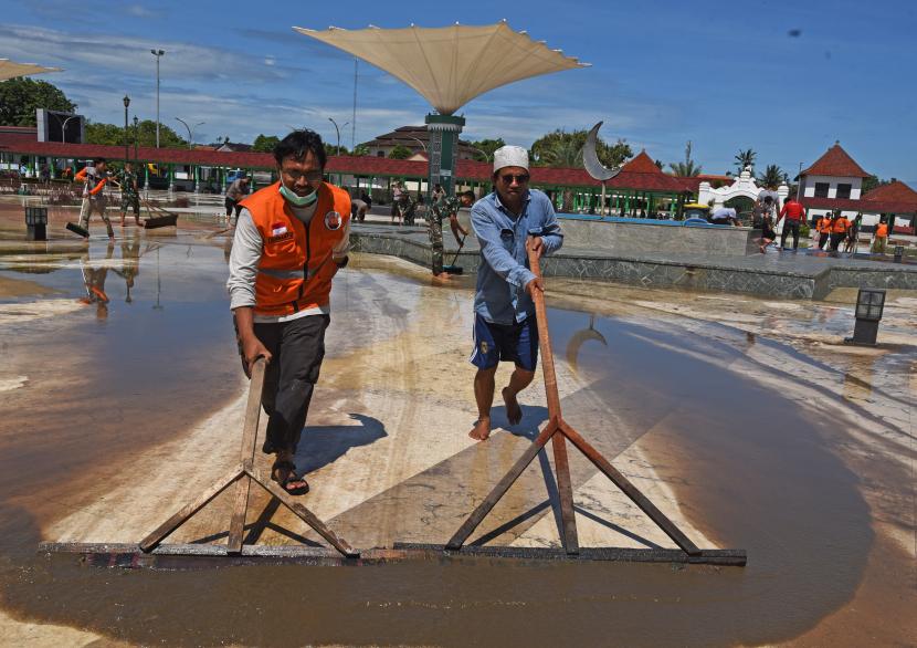 Sejumlah relawan bergotong royong membersihkan halaman Masjid Kesultanan Banten usai banjir menyusut di Kasemen, Serang, Banten, Kamis (3/3/2022).
