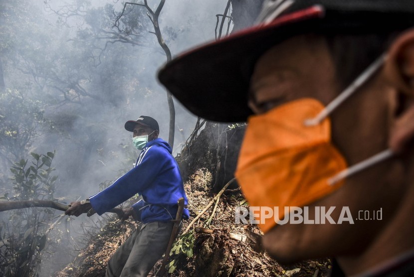 Sejumlah relawan berusaha memadamkan api yang membakar lahan di kawasan Kawah Putih, Kecamatan Pasirjambu, Kabupaten Bandung, Selasa (8/10).