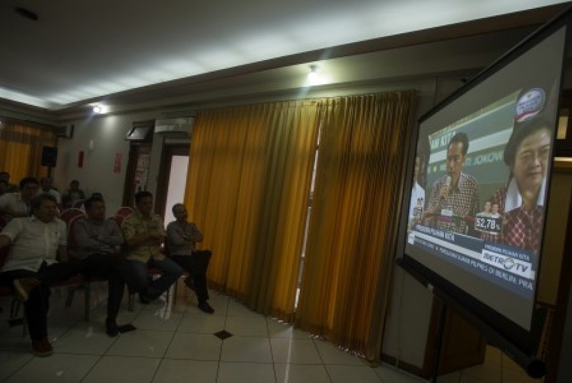Sejumlah relawan dan anggota tim pemenangan menyaksikkan hasil quick count Pemilu Presiden 2014 melalui layar lebar di Posko Pemenangan Jokowi-JK, Jl Cemara 19, Menteng, Jakarta, Rabu (9/7). 