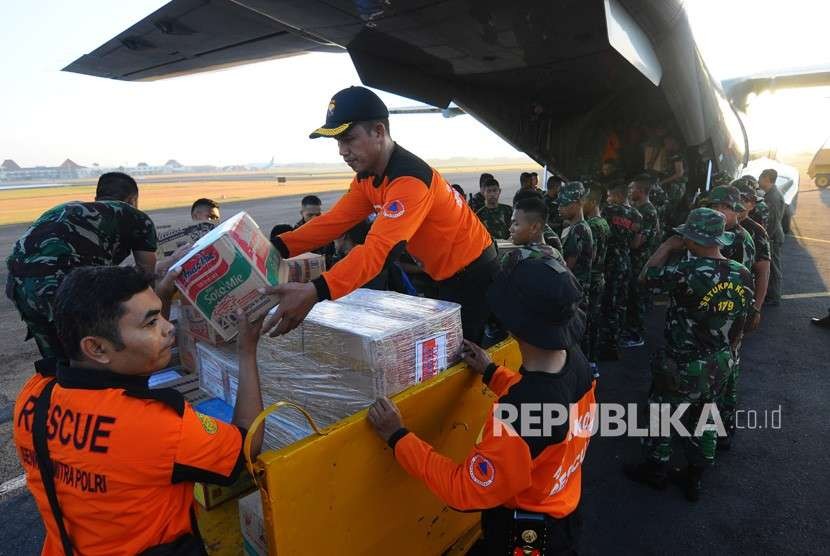 Sejumlah relawan dan prajurit TNI Angkatan Udara memasukkan bantuan ke dalam pesawat jenis CN-295 di Pangkalan TNI AU Adi Soemarmo, Boyolali, Jawa Tengah, Sabtu (11/8). 