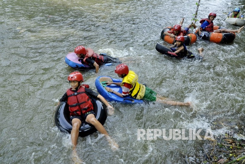 Sejumlah relawan dari Komunitas Cikapundung dan warga menyusuri Sungai Cikapundung dengan menggunakan ban bekas atau 