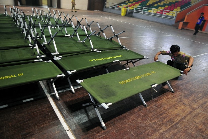 Sejumlah relawan dari Taruna Siaga Bencana Riau mempersiapkan tempat tidur lipat di Gelanggang Olah Raga Tribuana, Pekanbaru, Riau, Rabu (16/9). 