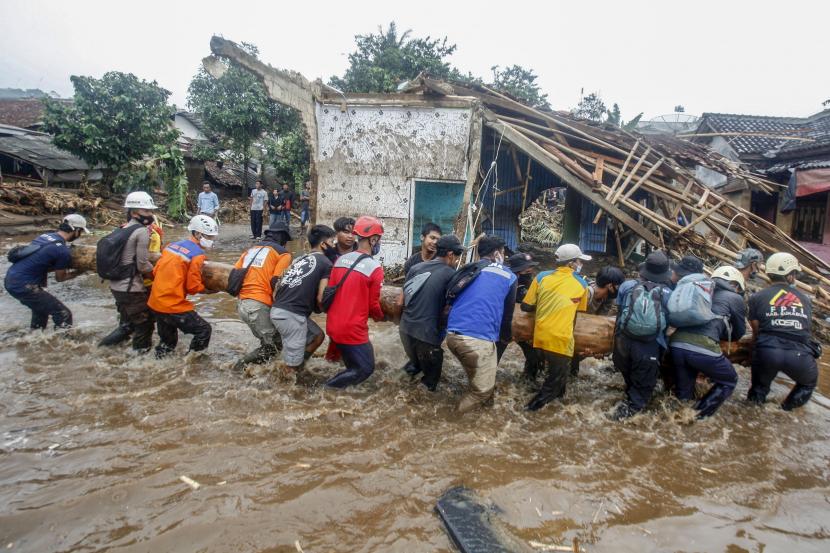 Sejumlah relawan gabungan mengevakuasi material kayu yang terbawa banjir bandang di Kampung Cibuntu, Desa Pasawahan, Kecamatan Cicurug, Sukabumi, Jawa Barat.