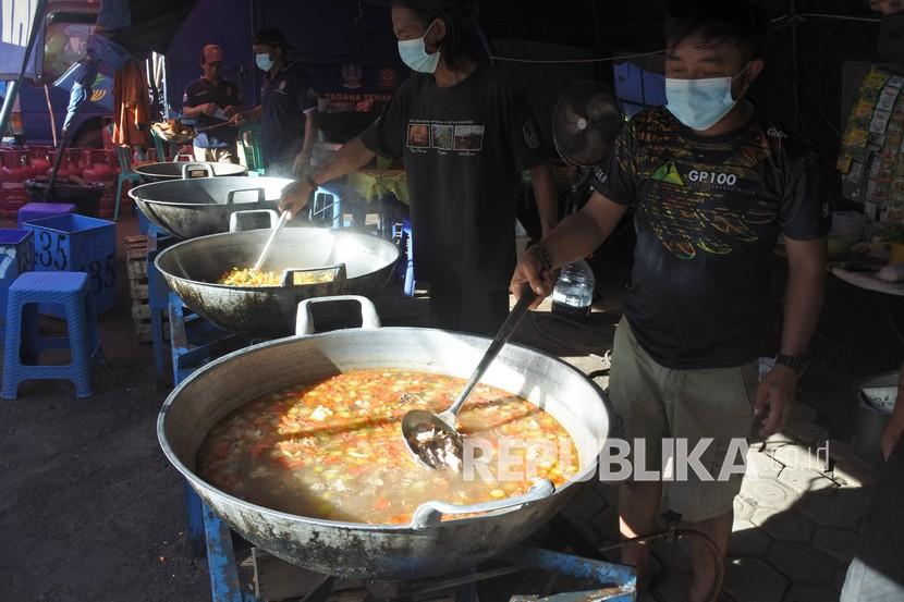Sejumlah relawan memasak sajian berbuka puasa untuk pengungsi awan panas guguran (APG) Gunung Semeru di posko pengungsian Lapangan Desa Penanggal, Candipuro, Lumajang, Jawa Timur, Rabu (6/4/2022). Posko dapur umum Tagana Provinsi Jawa Timur menyiapkan 450 bungkus sajian berbuka puasa dan sahur bagi pengungsi APG Gunung Semeru. 