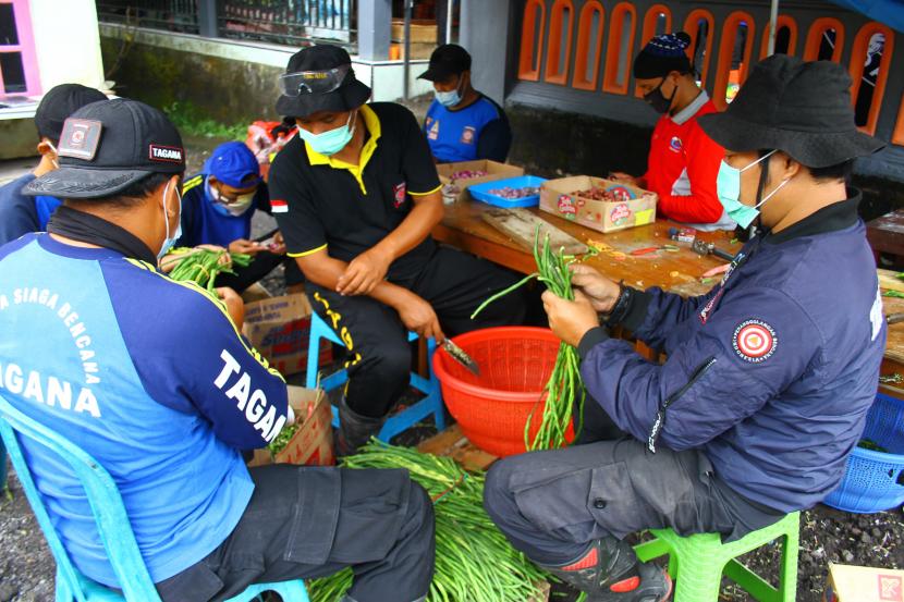 Sejumlah relawan memotong sayuran untuk bahan makanan bagi pengungsi letusan gunung Semeru di Dapur Umum Tagana di Pronojiwo, Lumajang, Jawa Timur, Senin (6/12/2021). Dapur umum tersebut setiap harinya memasok sedikitnya 1.500 bungkus makanan untuk para pengungsi dan relawan.
