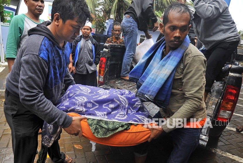 Sejumlah relawan mengevakuasi korban meninggal dunia akibat gelombang tsunami dari Pantai Sembolo, Carita, Pandeglang, Banten, ke Puskesmas Labuhan, Ahad (23/12/2018).