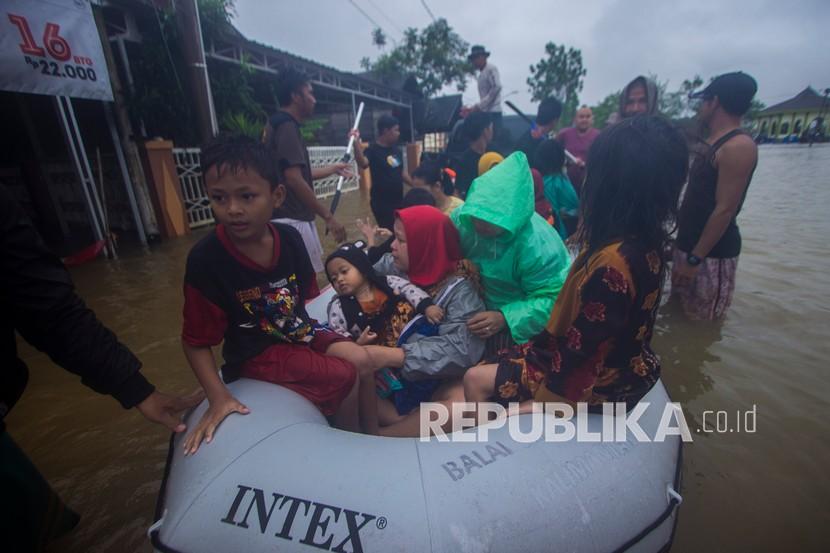 Sejumlah relawan menggunakan perahu karet membantu evakuasi warga yang terdampak banjir di Desa Kampung Melayu, Kabupaten Banjar, Kalimantan Selatan, Jumat (15/1/2021). Presiden Joko Widodo (Jokowi) memerintahkan pengiriman bantuan untuk penanganan bencana banjir di Kalimantan Selatan. 