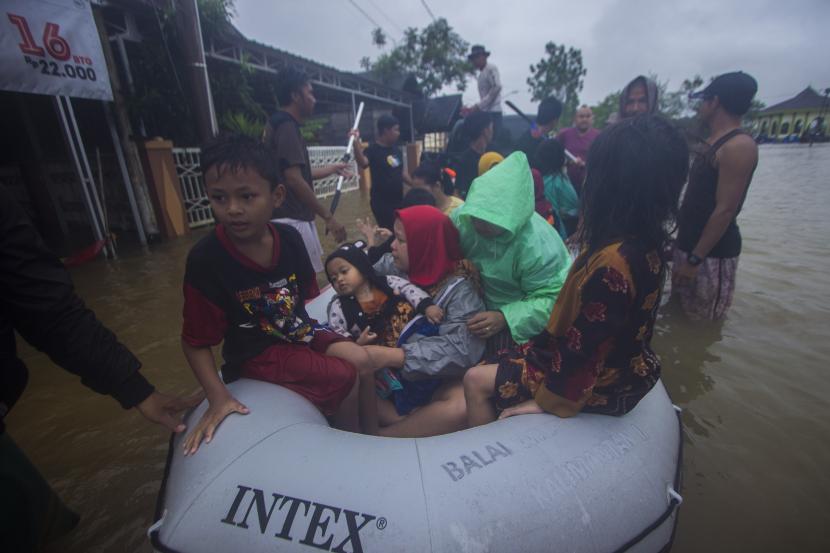 Sejumlah relawan menggunakan perahu karet membantu evakuasi warga yang terdampak banjir di Desa Kampung Melayu, Kabupaten Banjar, Kalimantan Selatan.
