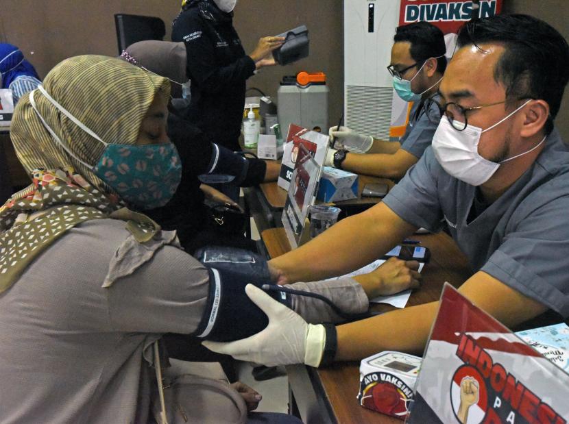 Sejumlah relawan yang tergabung dalam Gerakan Indonesia Pasti Bisa (GIPB) memeriksa kesehatan warga saat menggelar vaksinasi COVID-19 keliling di Gedung Training Center UPI di Serang, Banten, Sabtu (13/11/2021). Vaksinasi dilakukan di lokasi yang dipilih dan diinginkan warga untuk memberi kemudahan akses bagi semua warga di sekitar lokasi yang belum mendapat vaksinasi COVID-19 guna mempercepat penuntasan pencapaian kekebalan komunal (Herd Immunity) dan Indonesia bebas COVID-19. 
