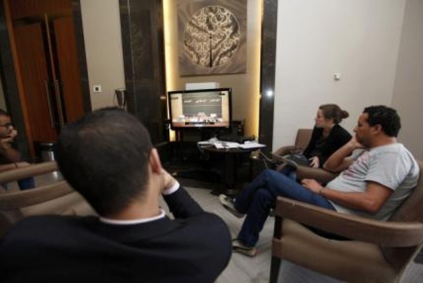 Sejumlah reporter menonton siaran langsung pelantikan pengusaha Ahmed Maiteeq sebagai perdana menteri Libya di televisi  yang terdapat di gedung parlemen Libya, Ahad (4/5).