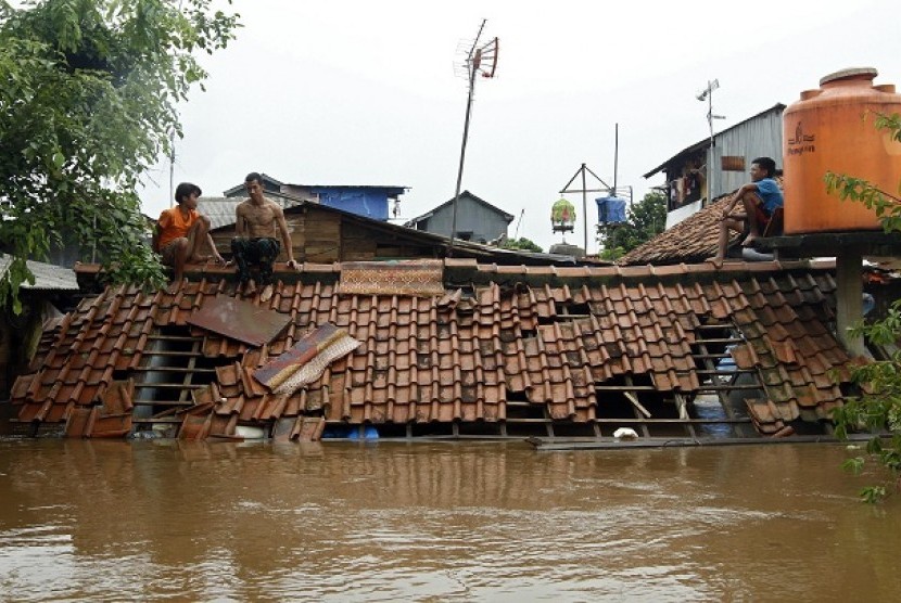 Sejumlah rumahwarga bertahan di atap rumah yang terendam banjir di bantaran sungai Ciliwung, Kampung Melayu, Jakarta Timur. Jumat (13/1). 