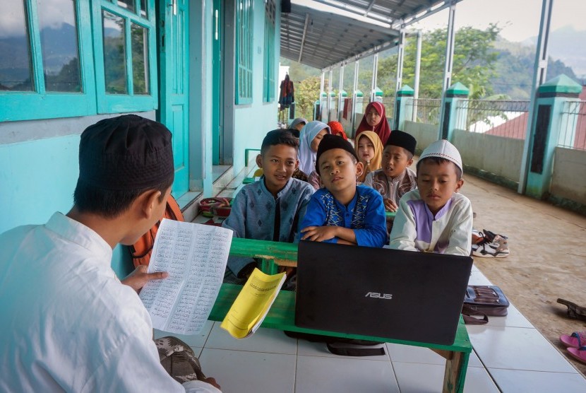 Sejumlah santri dipandu guru agama belajar Alquran melalui komputer jinjing yang terhubung internet di Desa Yosorejo, Kecamatan Petungkriyono, Kabupaten Pekalongan, Jawa Tengah