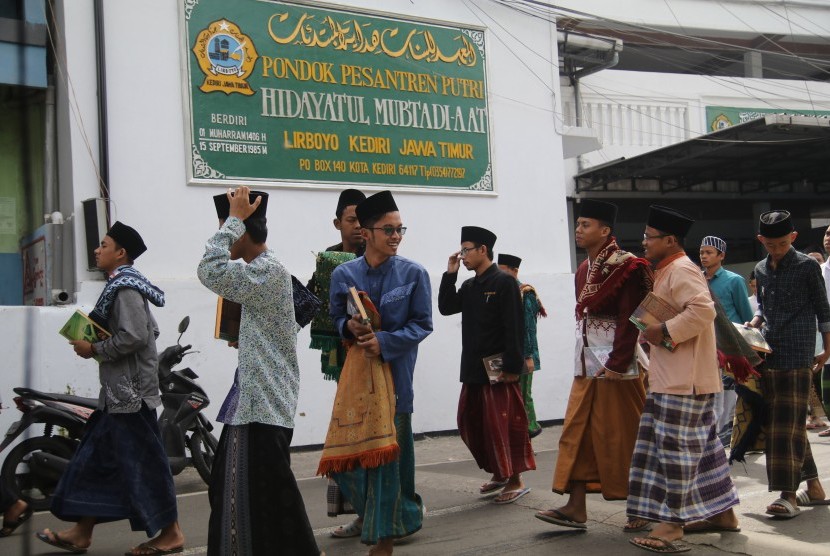 Sejumlah santri keluar dari dalam ruangan usai mengaji kitab kuning (kitab klasik berbahasa arab gundul) di pondok pesantren Lirboyo, Kota Kediri, Jawa Timur, Kamis (9/5/2019).
