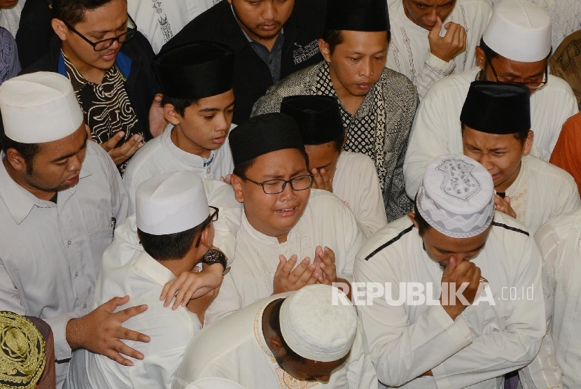 Sejumlah santri menangis saat mendoakan almarhum ulama KH Ali Mustofa Yaqub di Masjid Darussunnah, Ciputat, Tangerang Selatan, Banten, Kamis (28/4).Republika/Raisan Al Farisi