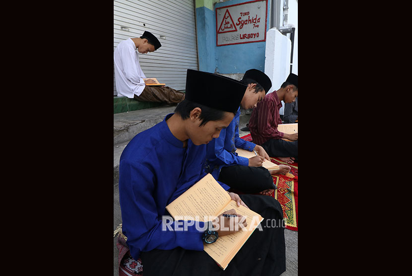 Sejumlah santri mengaji kitab kuning (kitab klasik berbahasa arab gundul) di komplek pondok pesantren (ponpes) Lirboyo, Kota Kediri, Jawa Timur, Jumat (25/5).