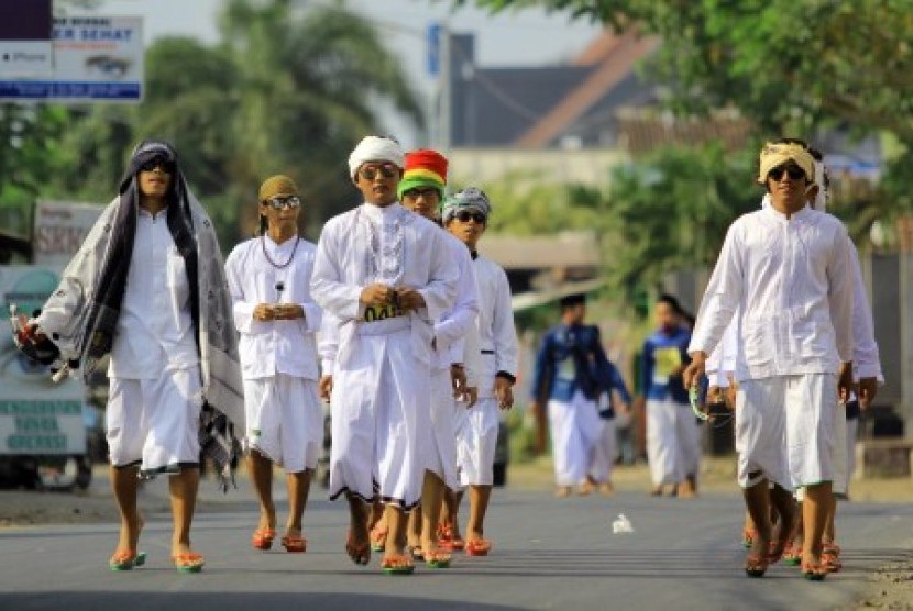 Sejumlah santri mengikuti gerak jalan dengan memakai pakaian khas pesantren saat acara Festival santri di Ruang Terbuka Hijau Maron, Banyuwangi, Jawa Timur, Minggu (27/9). 