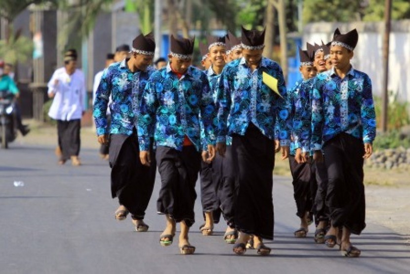 Sejumlah santri mengikuti gerak jalan dengan memakai pakaian khas pesantren saat acara Festival santri di Ruang Terbuka Hijau Maron, Banyuwangi, Jawa Timur, Minggu (27/9).