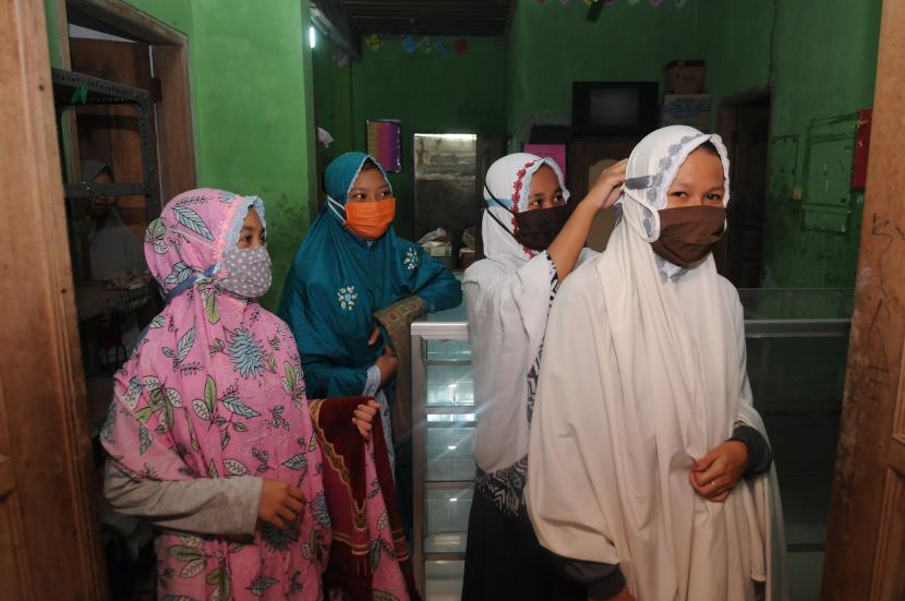 Sejumlah santri putri mengenakan masker saat akan Shalat Dzuhur di Pondok Pesantren 