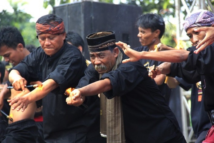 Sejumlah seniman debus melakukan atraksi permainan api pada acara Festival Debus, di Anyer, Serang, Banten, Sabtu (23/8). 