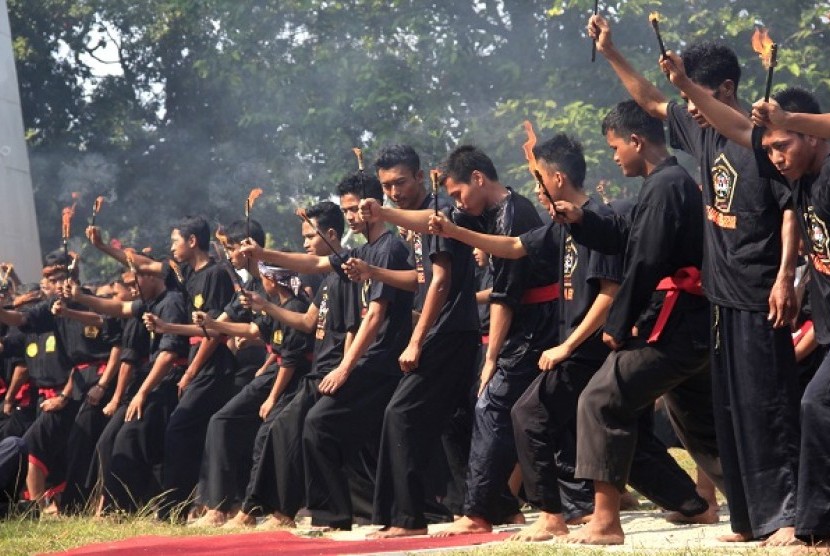 Sejumlah seniman debus menyalakan obor sebelum atraksi permainan api pada acara Festival Debus, di Anyer, Serang, Banten, Sabtu (23/8).
