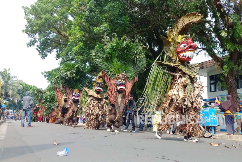 Sejumlah seniman menampilkan arak-arakan atraksi kesenian tradisional dalam kegiatan Golek Karnaval di Jalan KH Z Mustofa, Kota Tasikmalaya, Kamis (28/12/2023). Terdapat berbagai kesenian yang ditampilkan dalam atraksi itu, seperti Badawang dan Kuda Lumping dari Kota Tasikmalaya, Sisingaan dari Kabupaten Tasikmalaya, Bebegig dari Kabupaten Ciamis, Raja Dogar dari Kabupaten Garut, serta Buta Kararas dari Kota Banjar.