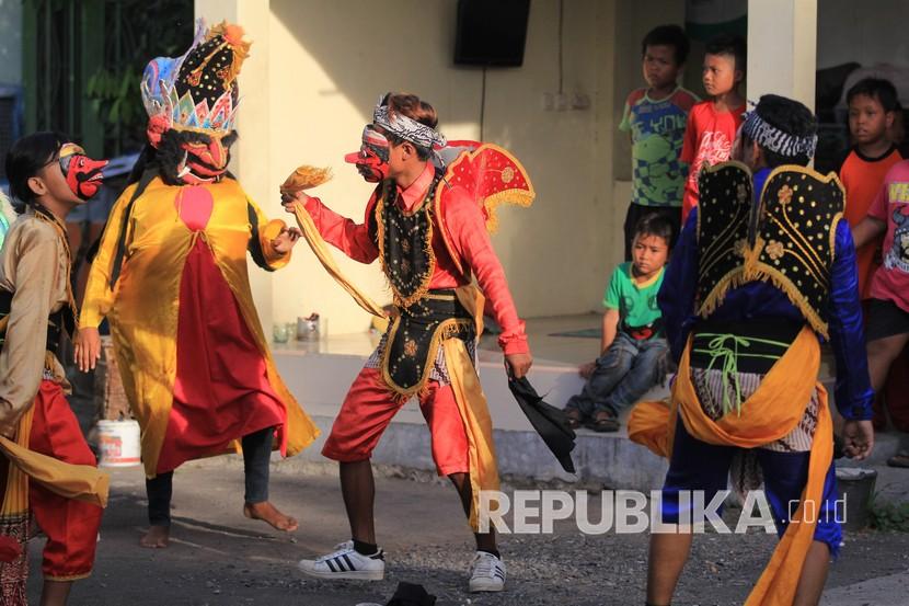 Sejumlah seniman tari dari kelompok Bleknong Pekandangan mengamen di jalan perkampungan Desa Pekandangan, Indramayu, Jawa Barat. Mereka mengaku terpaksa mengamen di jalanan karena sejak merebaknya wabah Covid-19 sudah tidak ada lagi pesanan untuk tampil di panggung pentas.