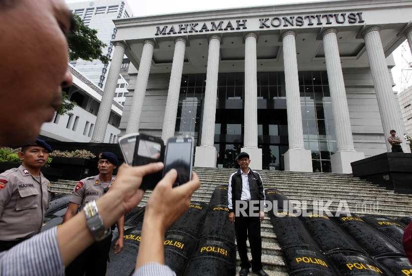 Sejumlah simpatisan asal daerah berfoto didepan gedung Mahkakamah Konstitusi (MK) saat berlangsungnya sidang panel lanjutan perselisihan hasil pemilihan (PHP) kepala daerah 2015 di Gedung Mahkamah Konstitusi, Jakarta, Kamis (21/1).