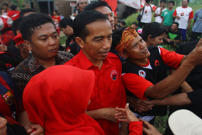   Sejumlah simpatisan berebut bersalaman dengan calon Presiden Joko Widodo, saat mengikuti kampanye PDIP di Lapangan Mulyorejo, Malang, Jawa Timur, Ahad (30/3).