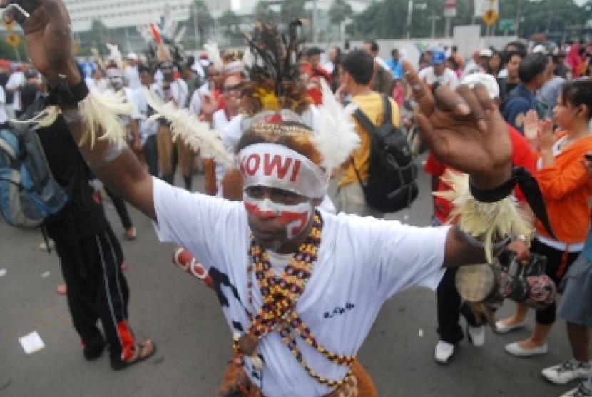 Sejumlah simpatisan yang tergabung dalam Komunitas Relawan Peduli Papua Bangkit dan Barisan Relawan Jokowi Presiden menari bersama saat melakukan aksi dukungan kepada Gubernur DKI Jakarta Joko Widodo di kawasan bundaran HI, Jakarta Pusat, Ahad (11/5).