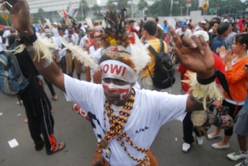 Sejumlah simpatisan yang tergabung dalam Komunitas Relawan Peduli Papua Bangkit dan Barisan Relawan Jokowi Presiden menari bersama saat melakukan aksi dukungan kepada Gubernur DKI Jakarta Joko Widodo di kawasan bundaran HI, Jakarta Pusat, Ahad (11/5). 