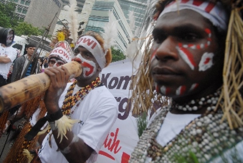 Sejumlah simpatisan yang tergabung dalam Komunitas Relawan Peduli Papua Bangkit dan Barisan Relawan Jokowi Presiden menari bersama saat melakukan aksi dukungan kepada Gubernur DKI Jakarta Joko Widodo di kawasan bundaran HI, Jakarta Pusat, Ahad (11/5).