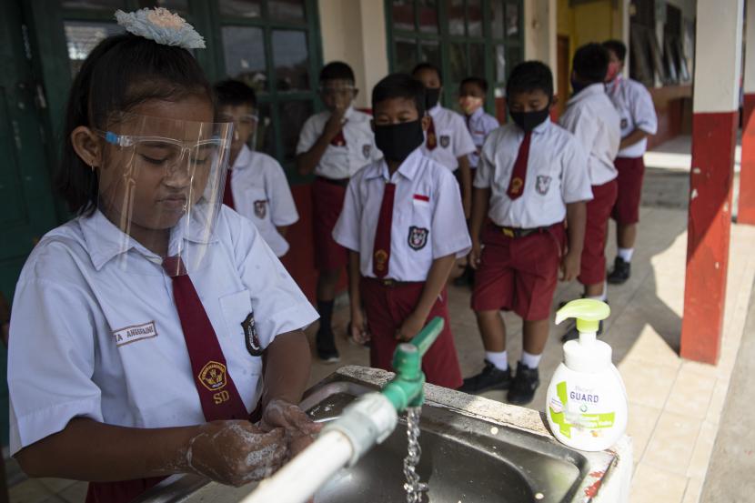 Sejumlah siswa antre mencuci tangannya sebelum mengikuti Kegiatan Belajar Mengajar (KBM) tatap muka di SD Negeri 26 Sukajadi, Banyuasin, Sumatera Selatan, Senin (7/9/2020). Pemerintah Kabupaten Banyuasin memberikan izin kepada sekolah di wilayah tersebut untuk melaksanakan KBM tatap muka dengan menerapkan protokol kesehatan secara ketat.