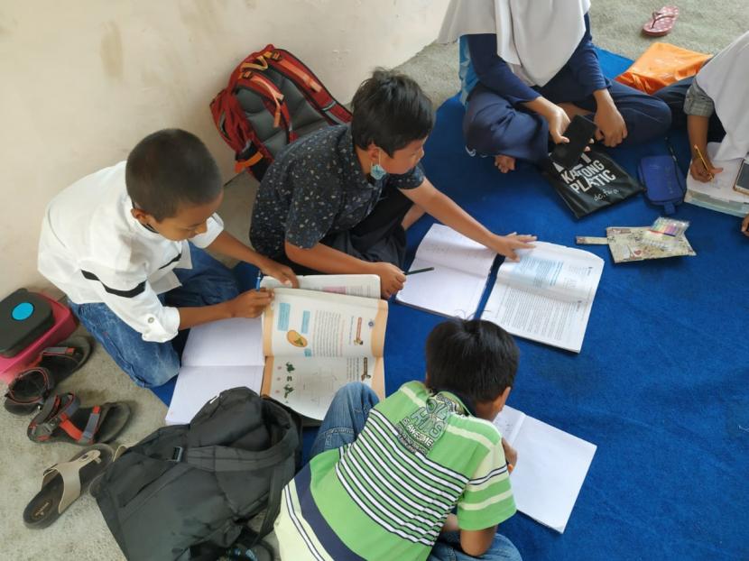  Sejumlah siswa belajar di sekretariat RW 09, Desa Sirnajaya, Kecamatan Tarogong Kaler, Kabupaten Garut, Rabu (12/8). Pihak RW setempat menyediakan akses internet gratis bagi siswa di lingkungan itu untuk belajar secara daring. 