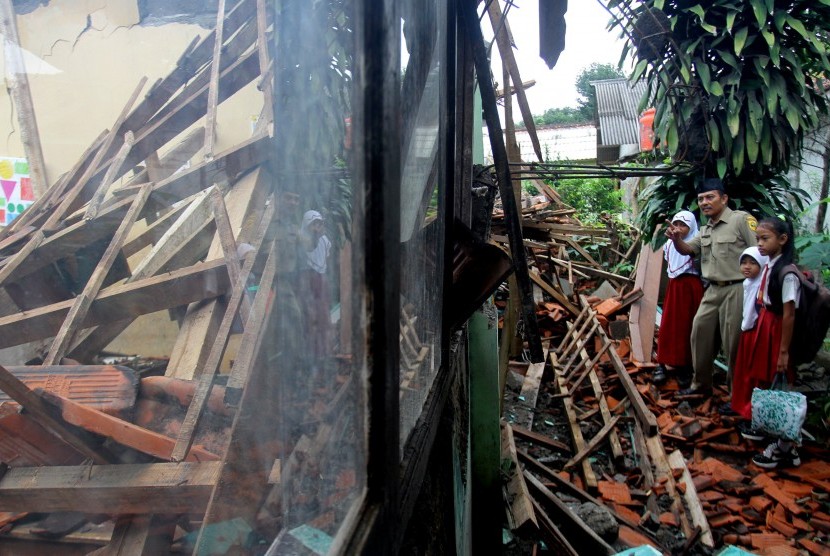 Sejumlah siswa dan guru melihat bangunan sekolahnya yang rusak di SDN Cibugis, Desa Cibugis, Kelapa Nunggal, Kabupaten Bogor, Jawa Barat, Senin (29/2).
