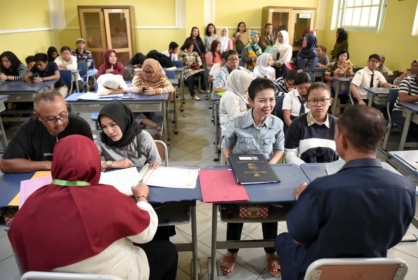 Sejumlah siswa dan orang tua murid antre mengikuti seleksi Penerimaan Peserta Didik Baru (PPDB) di SMAN 1 Jakarta, Jakarta, Senin (24/6/2019). 