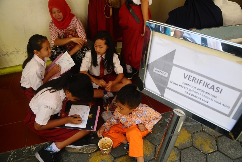 Sejumlah siswa dan orang tua murid antre untuk mengikuti seleksi Penerimaan Peserta Didik Baru (PPDB) di SMP 1 Kudus, Jawa Tengah, Rabu (19/6/2019).