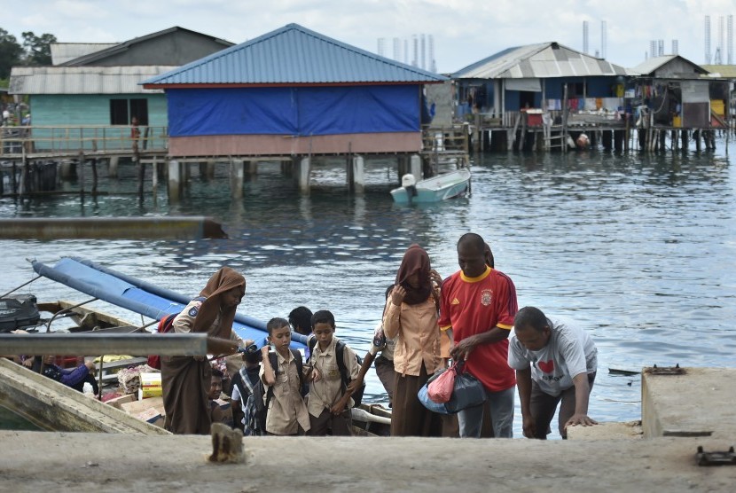  Sejumlah siswa dan warga turun dari boat pancung saat tiba di Pulau Lengkang, Batam, Rabu (25/5). (Antara/Puspa Perwitasari)