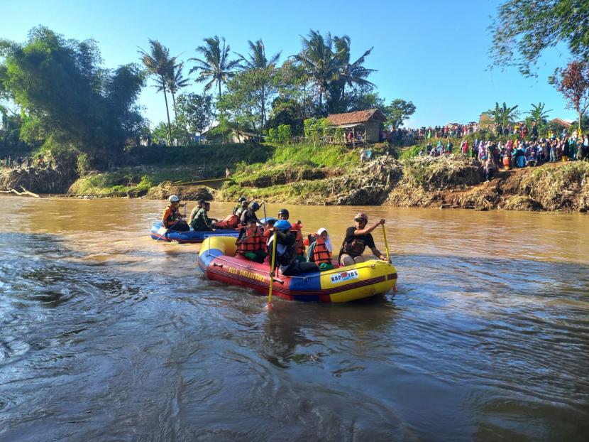 Sejumlah siswa melintasi Sungai Cimanuk di Kecamatan Banyuresmi, Kabupaten Garut, menggunakan perahu karet, Kamis (21/7/2022). Jembatan yang berada di wilayah itu rusak akibat terdampak banjir bandang yang terjadi pada Jumat (15/7/2022). 