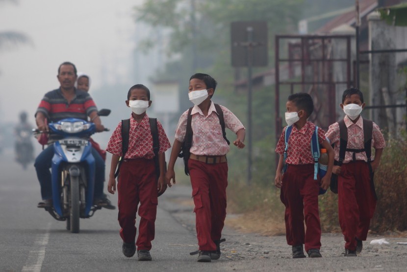Sejumlah siswa memakai masker saat berjalan menuju ke sekolah mereka, di Desa Suak Raya, Johan Pahlawan, Aceh Barat, Aceh, Kamis (27/7). 