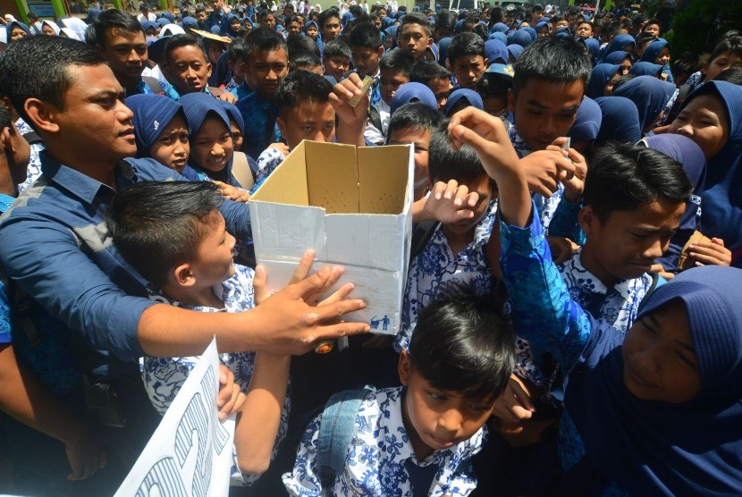 Sejumlah siswa memasukkan uang ke dalam kotak pada aksi penggalangan dana untuk korban gempa Aceh di SMP Negeri 10 Kota Tasikmalaya, Jawa Barat, Kamis (8/12).