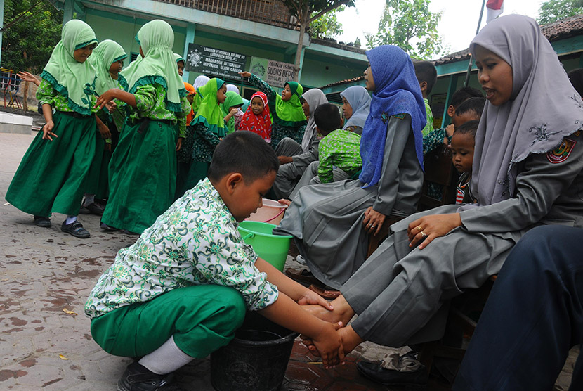 Sejumlah siswa membasuh kaki ibu guru mereka di Madrasah Ibtidaiyah (MI) Canden, Sambi, Boyolali, Jawa Tengah, Rabu (25/11).