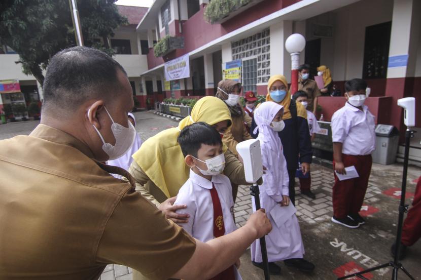 Sejumlah siswa mengecek suhu sebelum melakukan tes antigen di SDN Depok 1, Depok, Jawa Barat, Senin (18/10/2021). Pemerintah Kota Depok melakukan tes antigen COVID-19 secara acak bagi pelajar dan guru sejumlah sekolah untuk memastikan kesehatan siswa dan mencegah terjadinya klaster baru penyebaran COVID-19 di sekolah selama Pembelajaran Tatap Muka (PTM) Terbatas