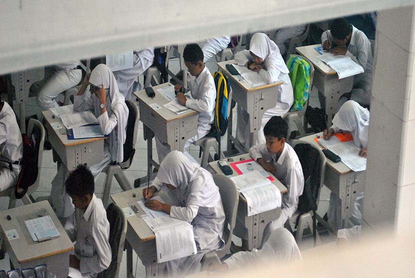Sejumlah siswa mengerjakan soal Ujian Nasional SD mata pelajaran Bahasa Indonesia di SD Insan Kamil, jalan raya Dramaga, Bogor, Jawa Barat, Senin (16/5). 