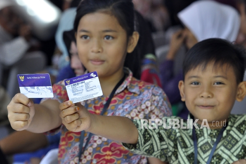 Sejumlah siswa menunjukan Kartu Indonesia Pintar sebelum kedatangan Presiden Republik Indonesia Joko Widodo saat kunjungan kerja di Taman Pendawa, Jalan Pendawa, Kota Bandung, Rabu (12/4).