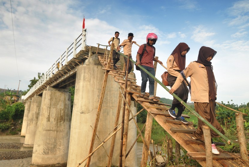Sejumlah siswa menuruni titian darurat untuk menyeberangi Sungai Jragung.