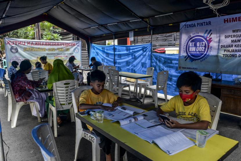 Sejumlah siswa saat melaksanakan pembelajaran jarak jauh di Tenda Pintar, Pondok Kelapa, Jakarta. Situasi pandemi yang mengharuskan siswa sekolah dan mahasiswa untuk belajar hanya di rumah secara daring membuat kejenuhan yang berkebalikan dengan kebutuhan sosial kelompok usia muda yang lebih tinggi. 