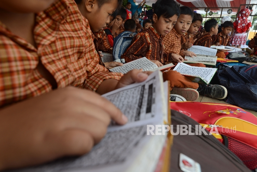 Sejumlah siswa SD 15 Cakranegara membaca Al Quran saat menonton MTQ di Islamic Center Kota Mataram, Nusa Tenggara Barat, Kamis (4/8)
